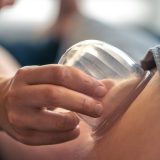 A clear cup works along the outer thigh with oil in a cozy studio. Vacuum boosts lymphatic drainage, contour and smooth skin for a trendy self care look.